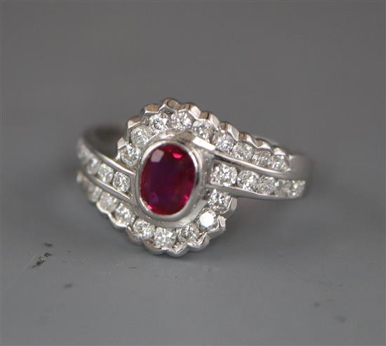 A modern stylish 18ct white gold, ruby and diamond oval cluster ring, with diamond set shoulders, size L/M.